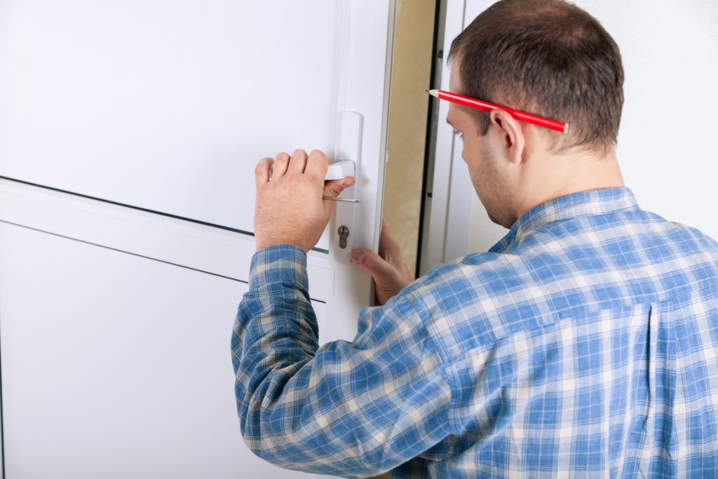 Technicien réparant une porte blanche